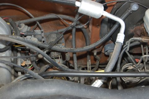 1989 Ford Bronco - A close-up view of a vehicle's engine bay, showing numerous hoses and electrical wiring.