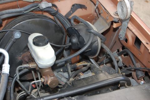 1989 Ford Bronco - Close-up view of the brake master cylinder and vacuum booster assembly in an engine bay.
