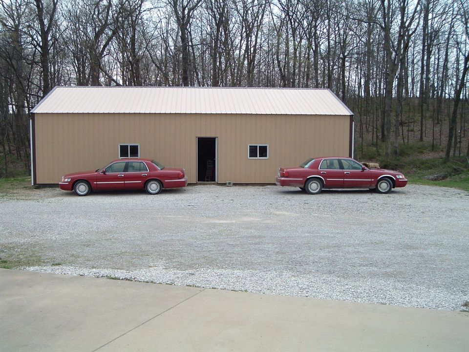 Two red 1999 Mercury Grand Marquis sedans parked side-by-side