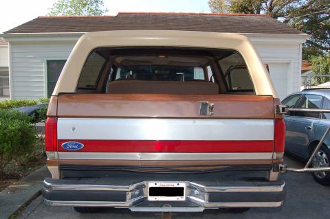 1989 Ford Bronco - The rear of a Ford Bronco shows its distinctive two-tone paint scheme and chrome bumper.