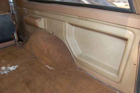 1989 Ford Bronco - Interior view showing a tan panel and brown carpeted wheel well.