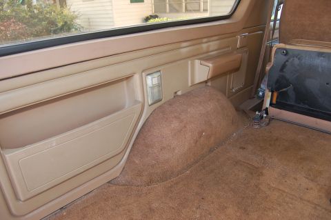 1989 Ford Bronco - Interior view of a 1989 Ford Bronco, highlighting the rear passenger side panel and carpeted wheel well.