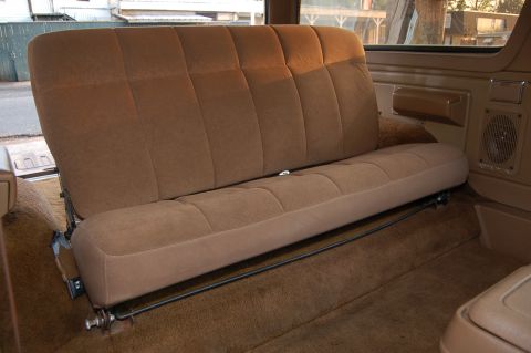 1989 Ford Bronco - The rear bench seat of the vehicle is shown with brown fabric upholstery and a carpeted floor.
