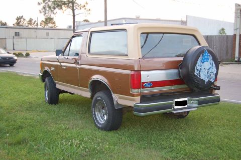1989 Ford Bronco - Rear view of a brown 1989 Ford Bronco with a spare tire cover a skull design.