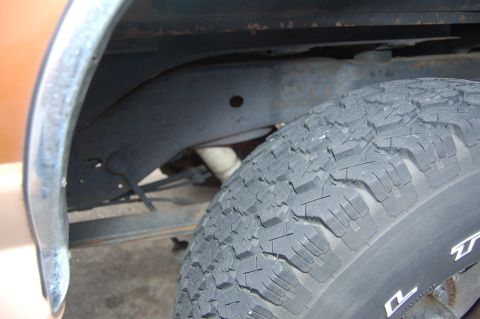 1989 Ford Bronco - This image focuses on the wheel well and tire, offering a partial view of the vehicle's undercarriage.