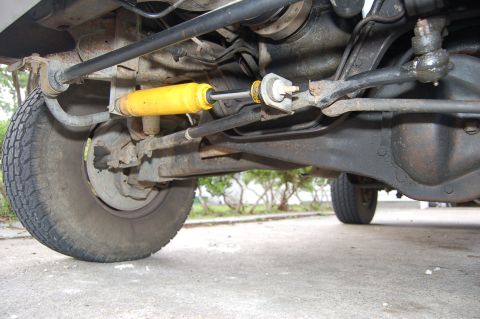 1989 Ford Bronco - Underside view of a vehicle's suspension system, showing the steering linkage and a shock absorber.