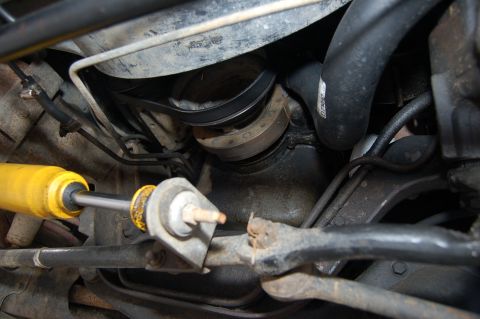 1989 Ford Bronco - Close-up view of an engine pulley and belt system, with a yellow shock absorber visible in the foreground.