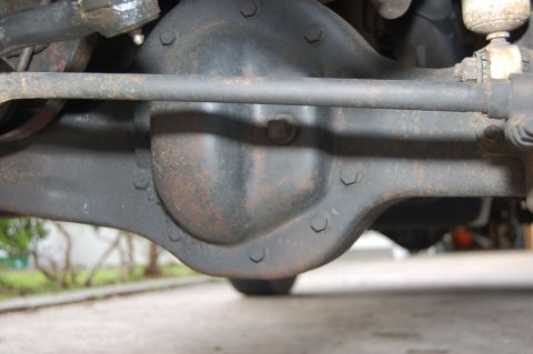 1989 Ford Bronco - Close-up view of a vehicle's rear axle differential housing and related suspension parts.
