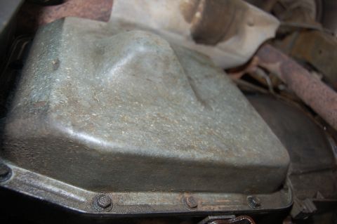 1989 Ford Bronco - Underside view of a vehicle's oil pan and surrounding components.