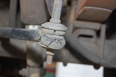 1989 Ford Bronco - Close-up view of deteriorated rubber bushings on a vehicle's stabilizer bar link.