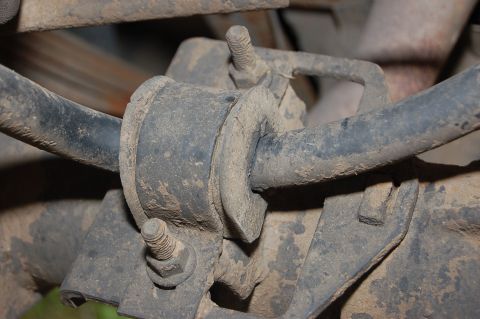 1989 Ford Bronco - Underside view of a vehicle's suspension system, focusing on a worn bushing.