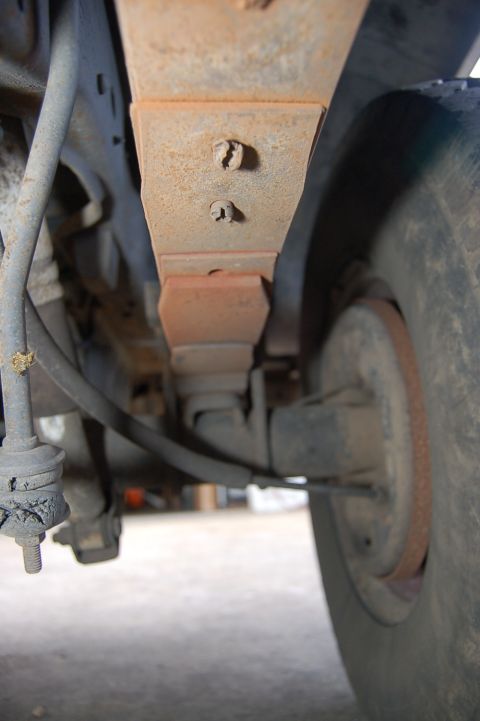 1989 Ford Bronco - Underside view of a vehicle's suspension system, focusing on a leaf spring and tire.