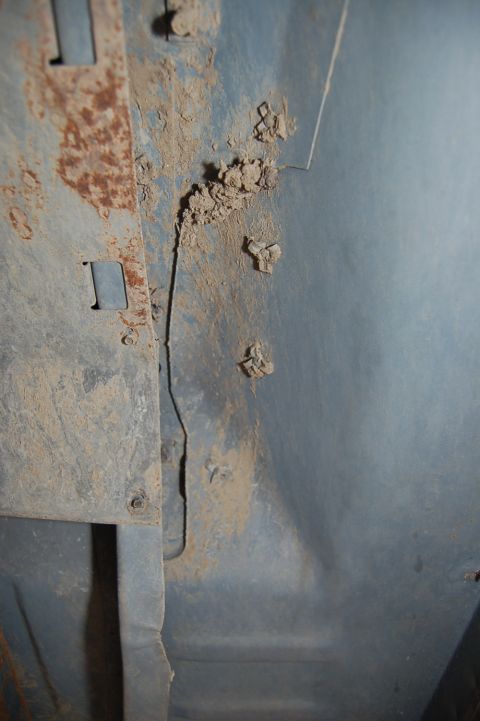 1989 Ford Bronco - The underside of a vehicle shows signs of rust and accumulated dirt and debris.