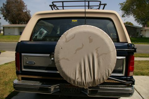1986 Ford Bronco - The rear of a Ford Bronco, showing its spare tire and roof rack.