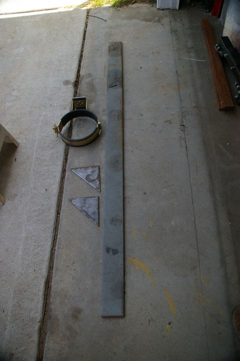 1986 Ford Bronco - Parts for a tank rack, including a clamp and metal strips, lie on a concrete surface.
