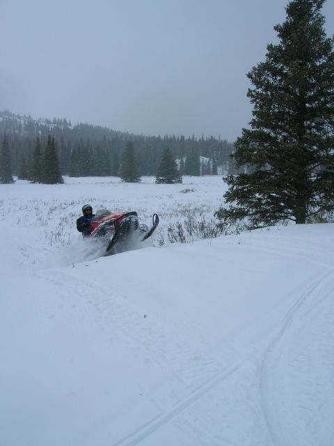 2003 Jeep TJ - Snowmobile rider navigating a snow-covered landscape during snowfall.