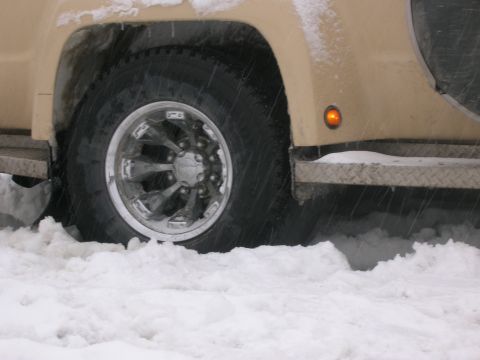 2003 Jeep TJ - Front wheel of a 2003 Jeep TJ partially buried in snow.