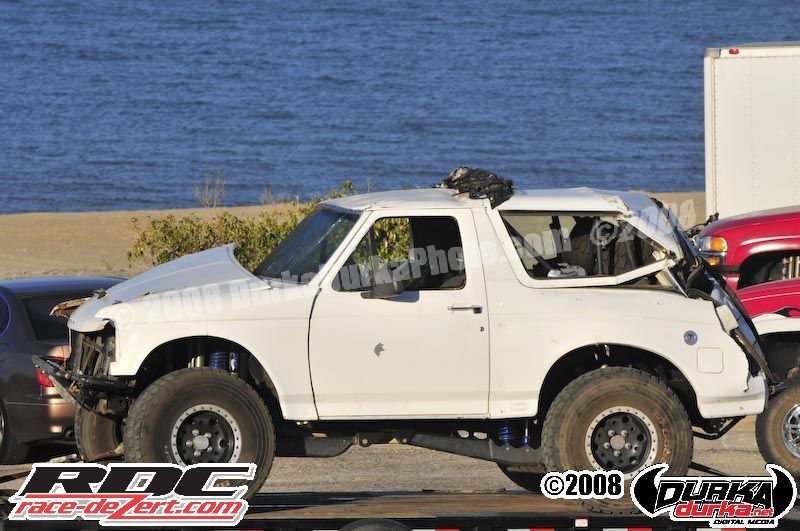White off-road SUV, side view, lifted suspension, damaged hood, 1996 model