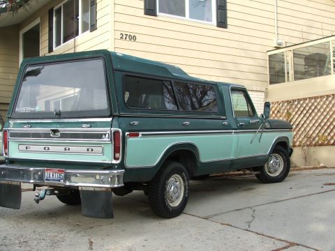 1979 Ford F-150 - This 1979 Ford F-150 pickup truck features a distinctive two-tone paint scheme and a camper shell, viewed from the rear.