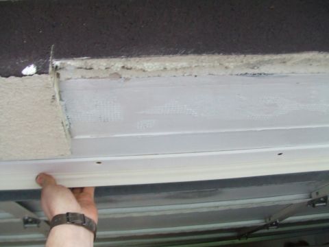 1996 Ford Bronco - A hand is shown adjusting the track of a garage door, with "SUPERMOTORS.NET" visible at the bottom right.