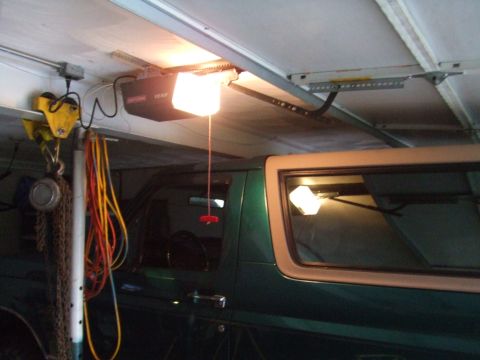 1996 Ford Bronco - A green SUV with tan trim is parked in a garage, with a garage door opener visible above.