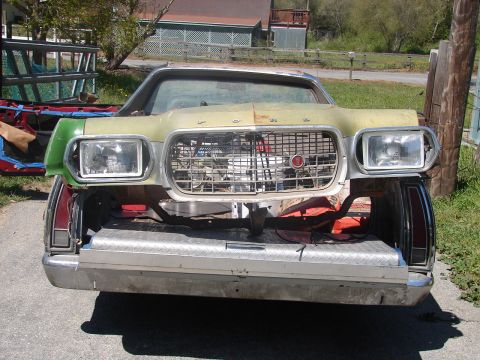 1973 Ford Ranchero - Rear view of a Ford Ranchero on a gravel driveway with its open tailgate and a diamond-plate panel, carrying a faded lime-green mid-1970s F…