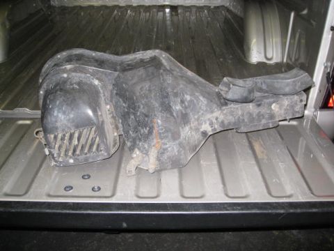 1994 Jeep YJ - A used automotive HVAC blower motor housing is placed in the bed of a pickup truck.