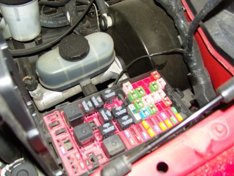 2007 Ford Mustang - Close-up view of a vehicle's engine bay fuse box, showing an assortment of relays and fuses.