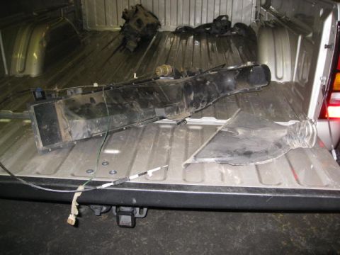 1994 Jeep YJ - Disassembled vehicle parts are stored in the bed of a pickup truck.