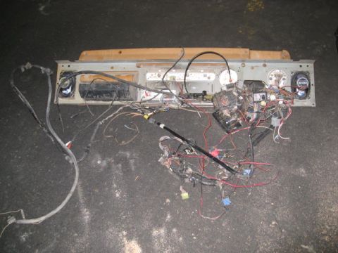 1994 Jeep YJ - A disassembled dashboard wiring harness with various electrical components and speakers is laid out on the ground.
