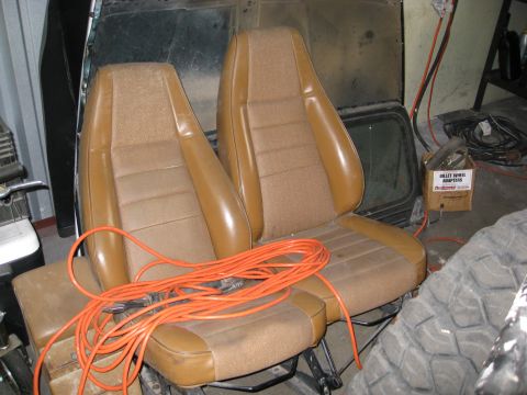 1994 Jeep YJ - Interior car seats are shown in a garage setting, with a tire and a box of adapters nearby.