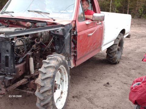 1982 Ford F-100 - This heavily modified pickup truck features large tractor tires and an exposed engine bay, suggesting it's built for off-road use.