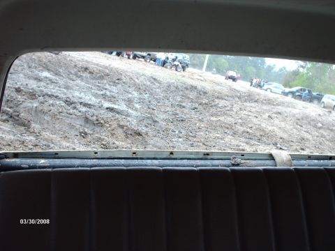 1982 Ford F-100 - Multiple vehicles are seen on a muddy hill, suggesting an off-road event or recreational activity.