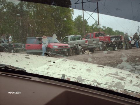 1982 Ford F-100 - Off-road gathering with multiple trucks and a red SUV in muddy conditions.