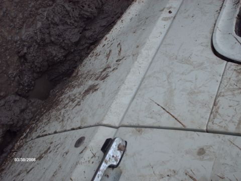 1982 Ford F-100 - A white truck is stuck in thick mud, with its door handle and a portion of the hood visible.