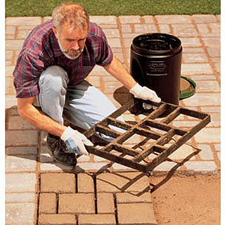 1984 Ford Bronco - A man uses a mold to create concrete pavers on a brick patio.