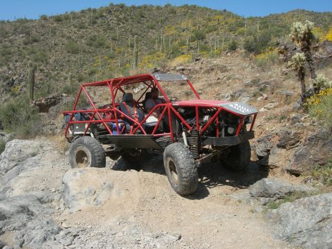 1974 Ford F-250 - This custom-built buggy navigates a challenging rocky trail under a clear blue sky.
