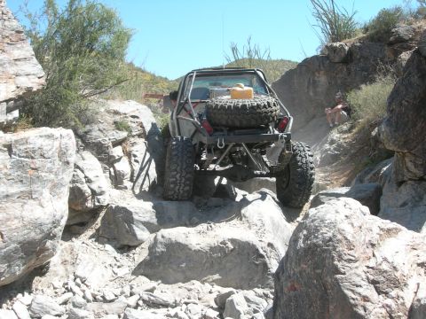 1974 Ford F-250 - Off-road vehicle navigating a challenging rocky terrain on a sunny day.