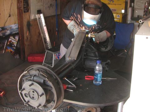 1968 Ford Mustang - A person welds a rear axle assembly in a workshop environment.