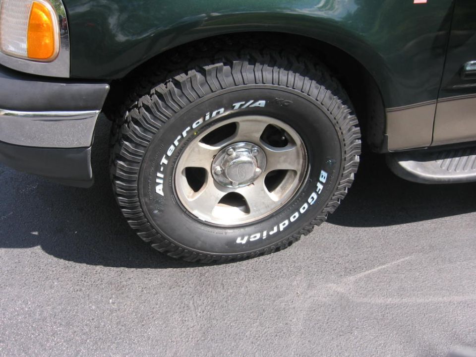 Front wheel of a green truck with BFGoodrich All-Terrain T/A tire