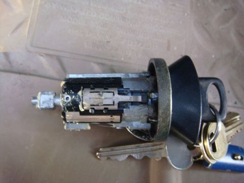 1996 Ford Bronco - A close-up view of an ignition lock cylinder assembly, complete with several keys on a keyring.