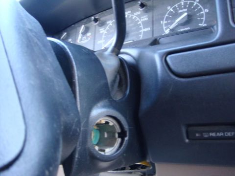 1996 Ford Bronco - Close-up of a vehicle's interior, focusing on the steering column and dashboard gauges. The ignition cylinder and a 'Rear Def' button are v…