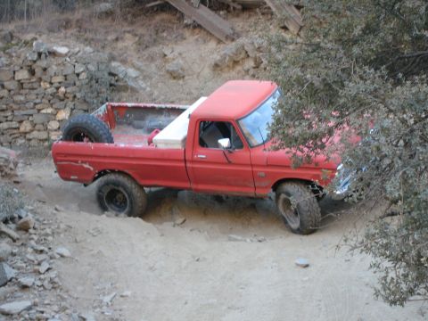 1974 Ford F-250 - This red 1974 Ford F-250 is navigating a rough, unpaved trail.