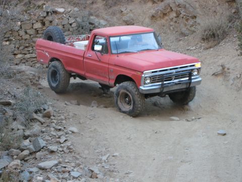 1974 Ford F-250 - Red 1974 Ford F-250 pickup truck navigates a rocky off-road trail.