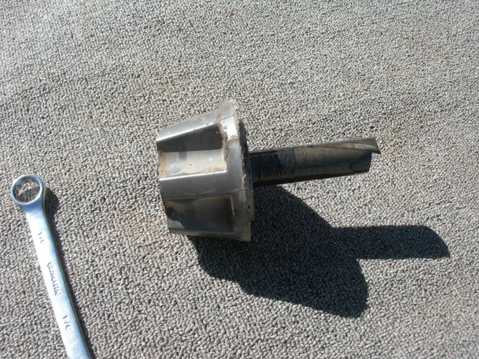 Broken stub shaft next to a combination wrench on a carpeted surface. "SUPERMOTORS www.supermotors.net" watermark