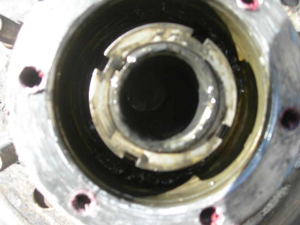Close-up of a vehicle's wheel hub assembly, showing internal splines and locking mechanism. Some grease is visible