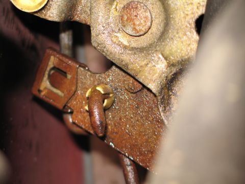 1995 Ford Bronco - Close-up view of a corroded door latch mechanism, showing intricate metal parts and a U-shaped bracket.