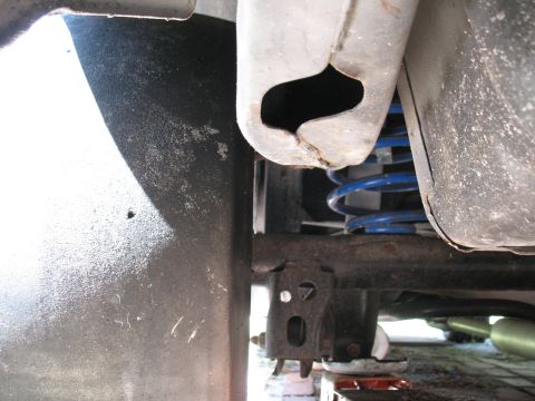 1985 Ford Crown Victoria LTD - This image shows the underside of a vehicle, focusing on the suspension system with a blue coil spring.