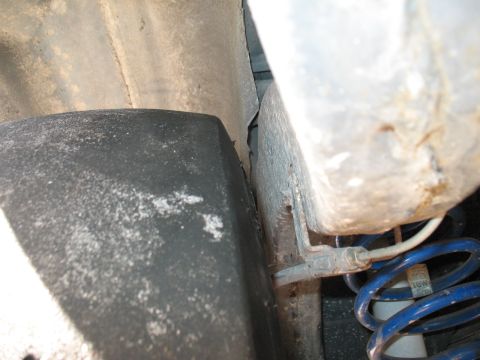 1985 Ford Crown Victoria LTD - Close-up of a vehicle's suspension system, showing a tire and brake line.