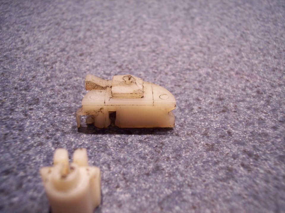 Plastic clip with two prongs on a textured surface